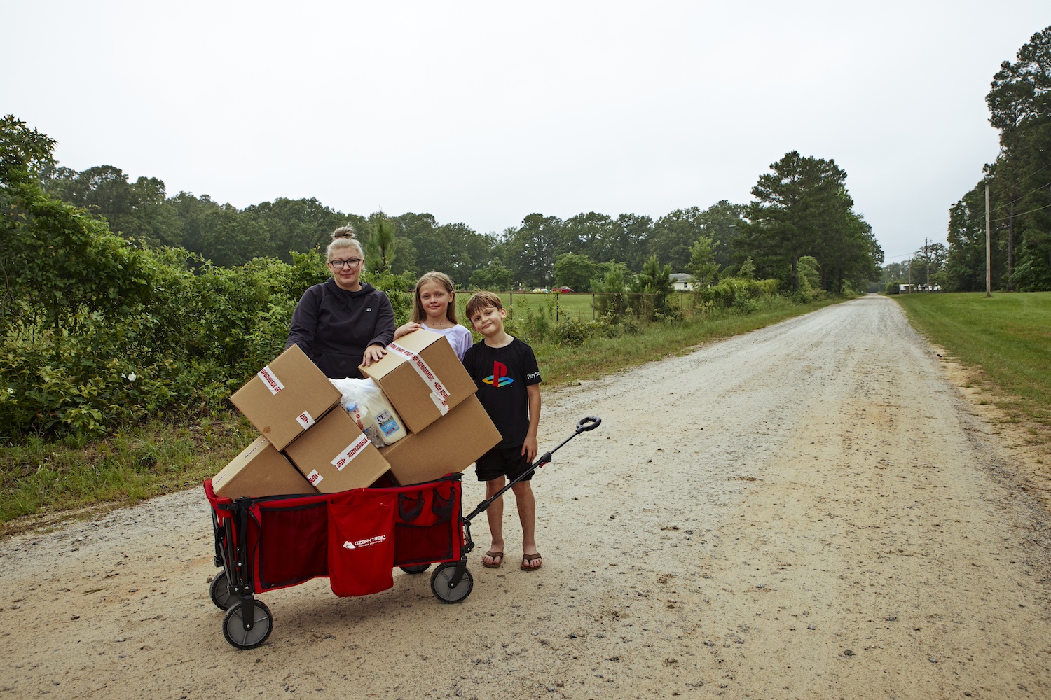 A family loads a wagon with boxes of food from the summer meal program.